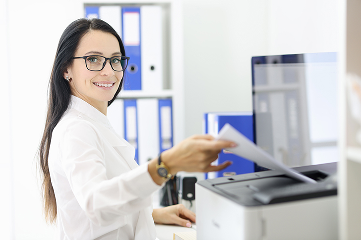 Woman at a desktop printer